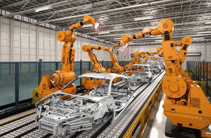 Yellow Robotic arms are working on the frames of cars on an assembly line